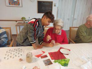 Schüler und Seniorin basteln